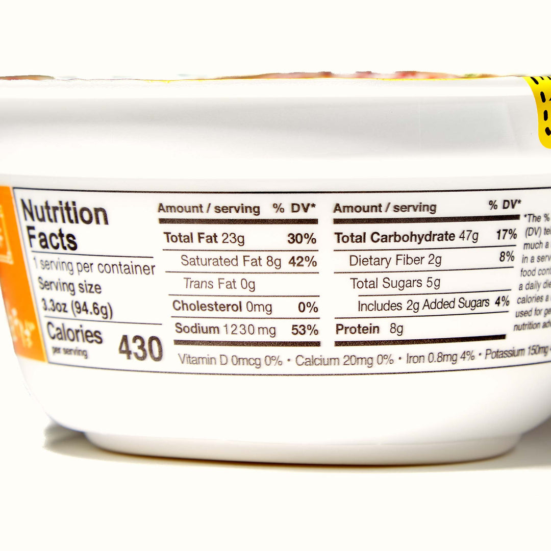 Close-up of a nutrition facts label on a Hikari Menraku Ramen Bowl: Tokyo Style "Soup-less" Ramen Rich Soysauce container showing calorie information and nutrient breakdown.