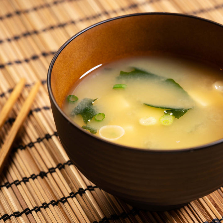 A bowl of Hikari Instant Miso Soup: Green Onion (8 servings) with chopsticks next to it.