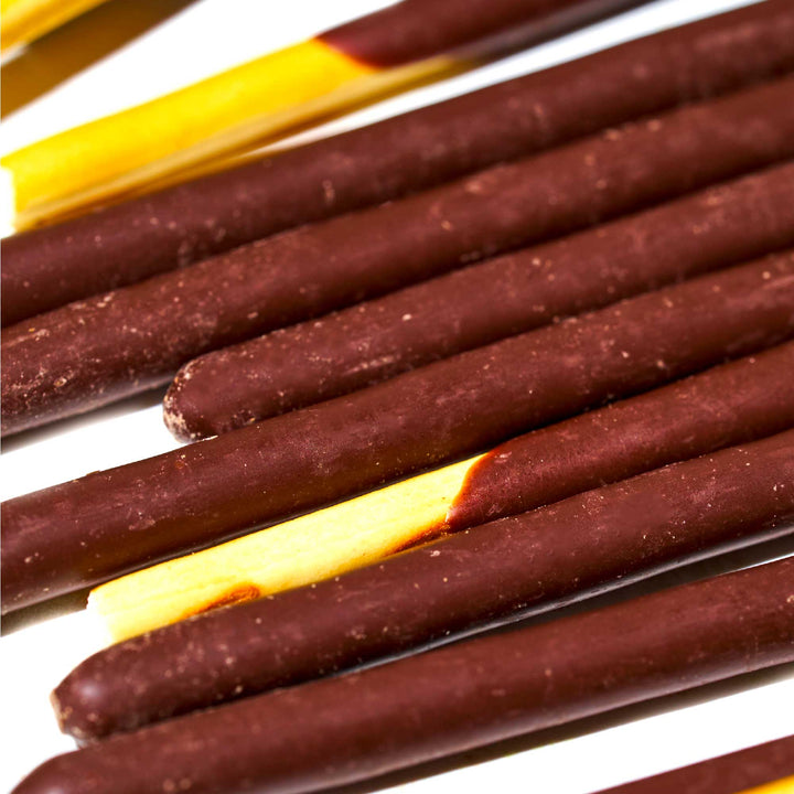 Close-up view of Glico Pocky: Chocolate, Japanese snack biscuit sticks dipped in chocolate, arranged in parallel rows.