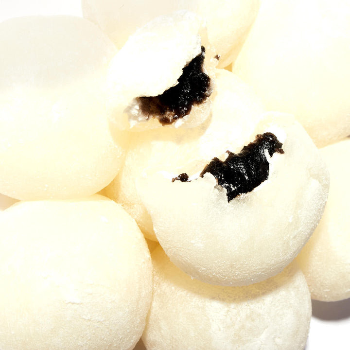 A pile of Kubota Daifuku Mochi: Black Sesame balls with a hole in the middle.