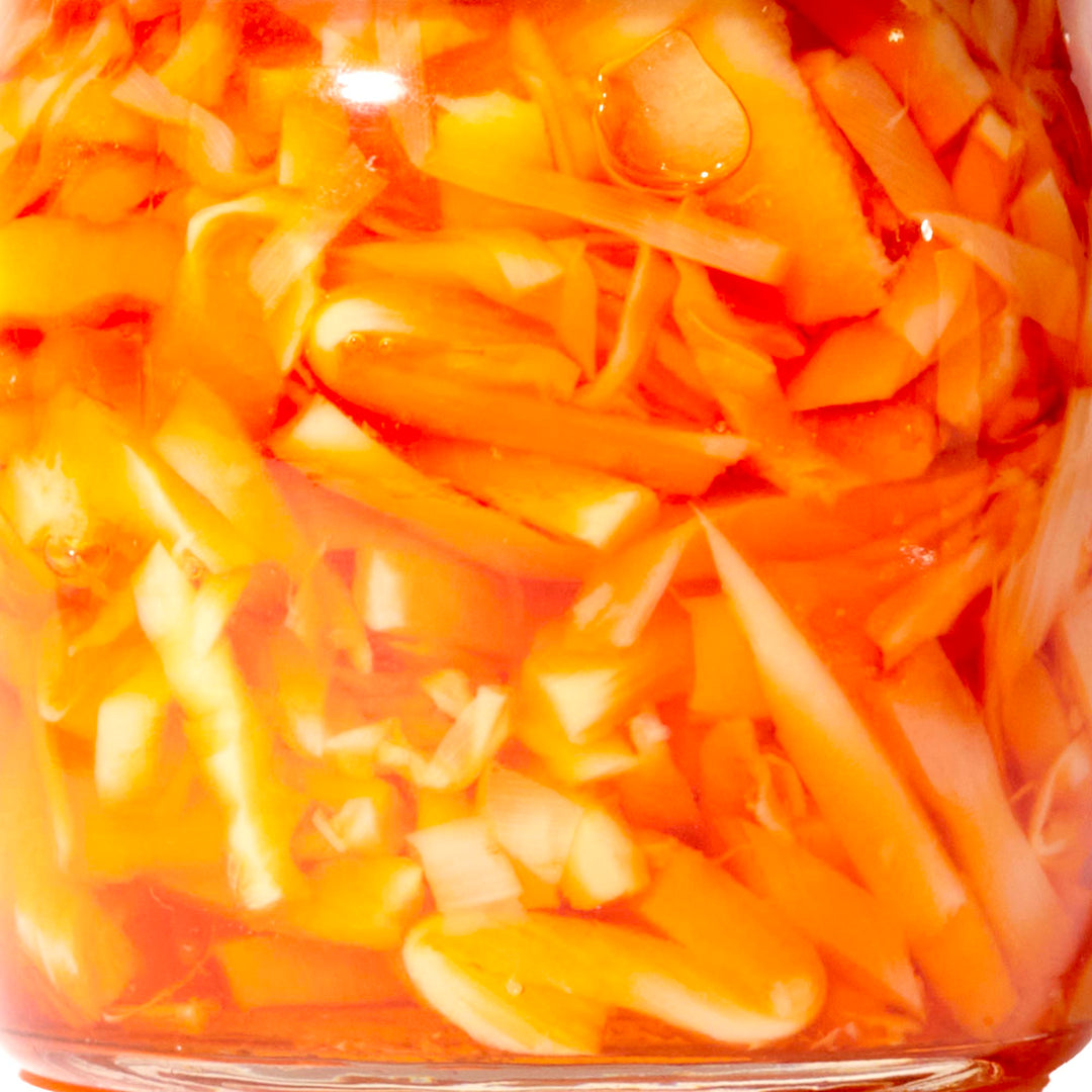 An Oriental Mascot jar of pickled bamboo shoot in chili oil on a white background.