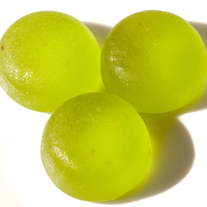 Three Kasugai Frutia Muscat Grape Gummies on a white surface.