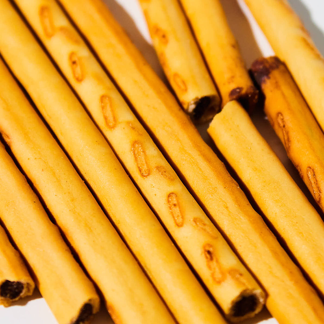 A group of Lotte Toppo: Vanilla Chocolate sticks on a white plate.
