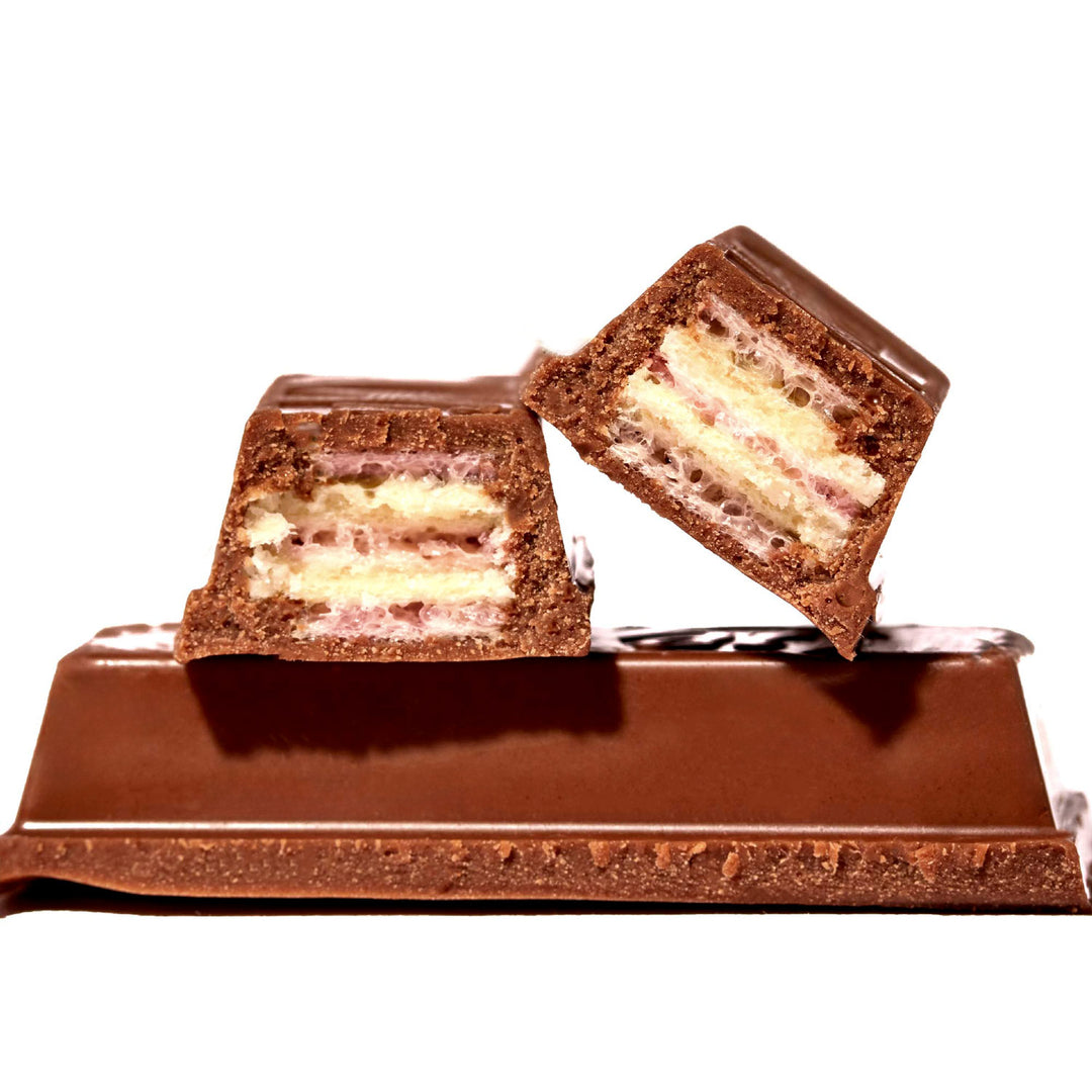 Two pieces of Nestle Japan's Japanese Kit Kat: Strawberry Chocolate Cake with visible layers of wafer and cream, one piece leaning on the other, isolated on a white background.