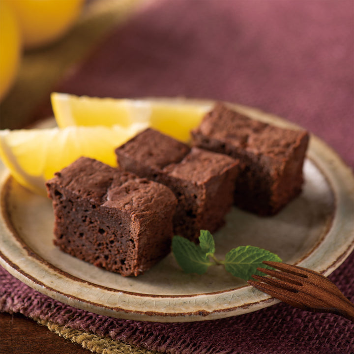 A plate with Kuze Fuku Poro Brownie: Japanese Citrus brownies and lemons on it.
