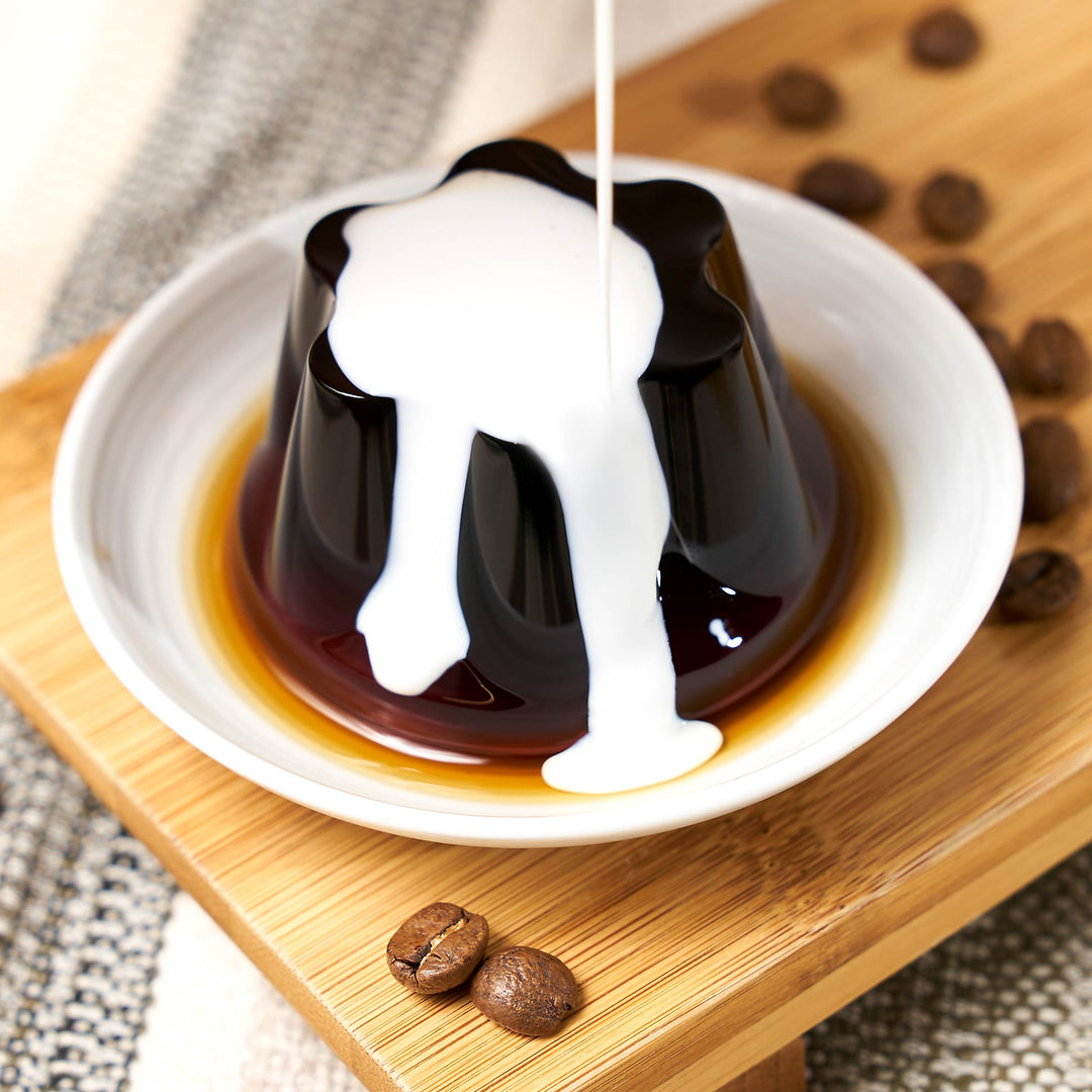 A cup of Okazaki coffee is being poured over a Okazaki Coffee Jelly Cups (3 packs) dessert.