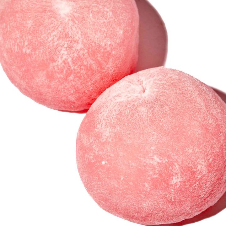 Two Kubota Daifuku Mochi: Peach balls on a white surface.