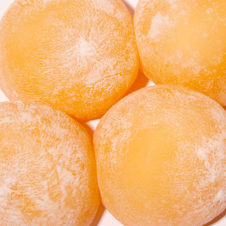A group of Kubota Daifuku Mochi: Mikan Orange on a white surface.