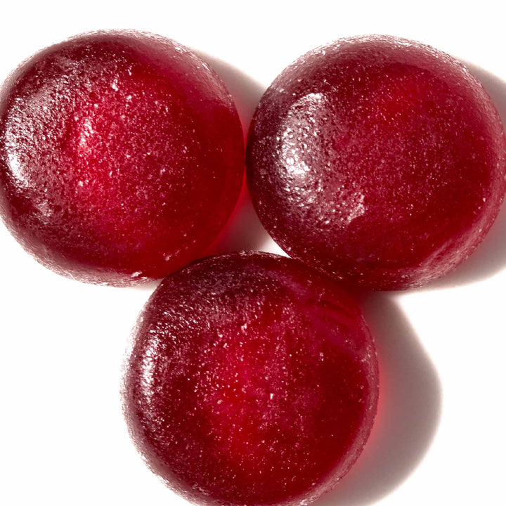 Three Kasugai Frutia Grape Gummy bears on a white surface.