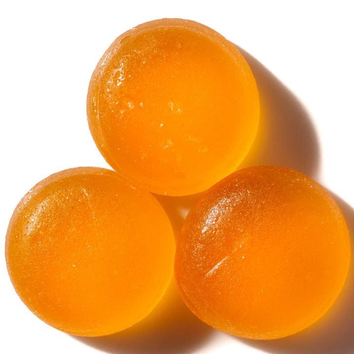 Three Kasugai Frutia Mango Gummy on a white surface.
