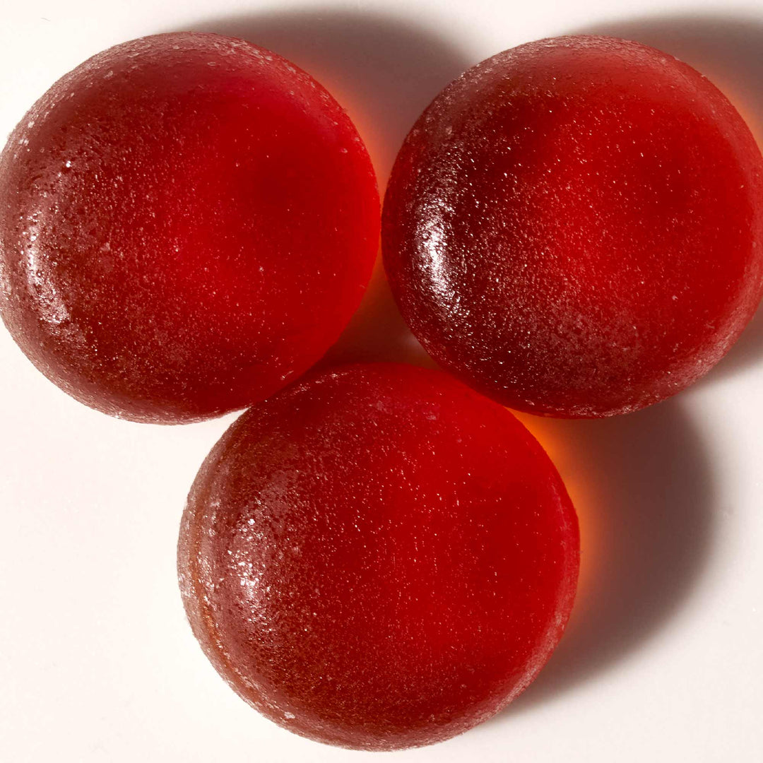 Three Kasugai Frutia Strawberry Gummy bears on a white surface.
