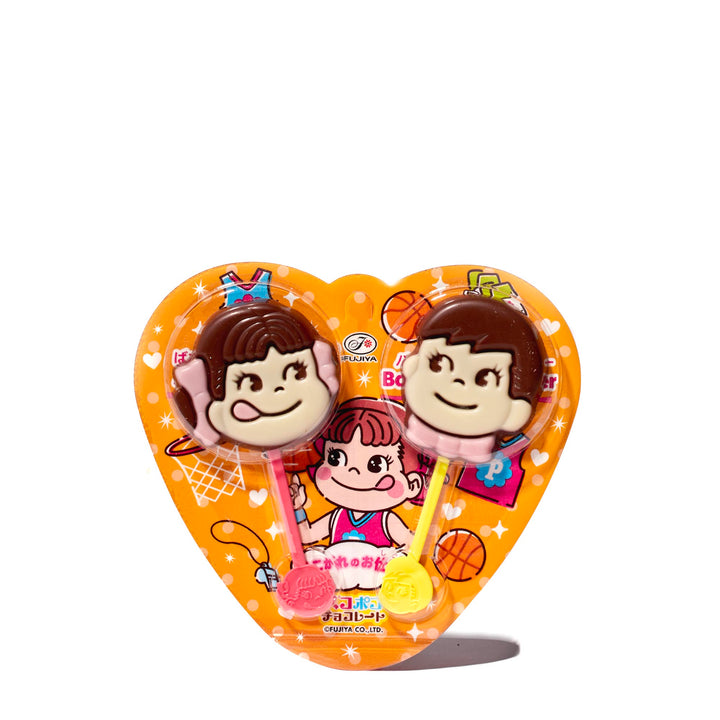 A heart shaped box with two Fujiya Pekopoko Chocolate Lollipop sticks in it.