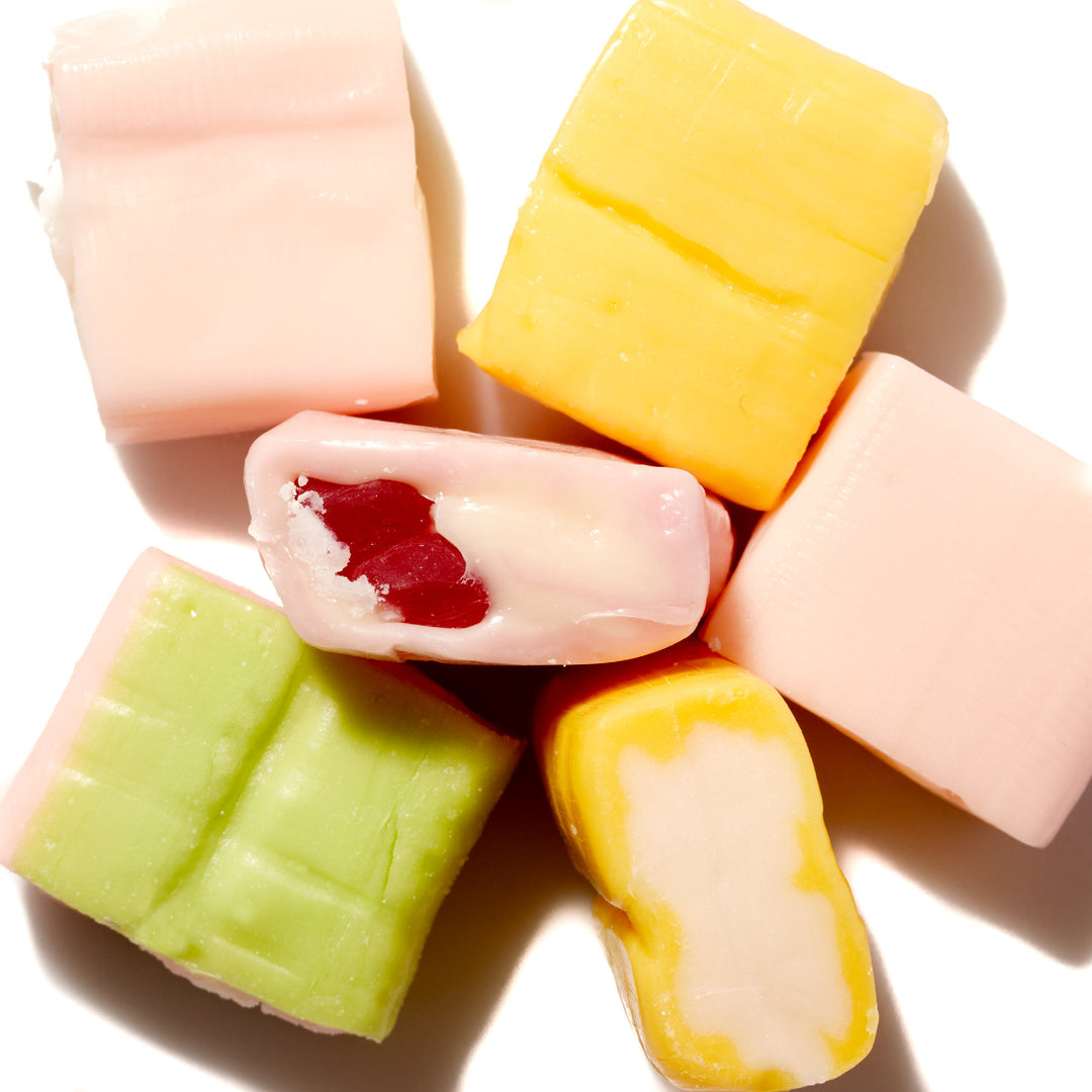 A group of UHA Mikakuto Puchao Gummy Candy: Soda Mix of different flavors on a white surface.
