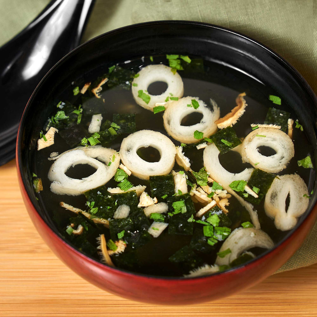A bowl of Nagatanien Matsutake Osuimono Mushroom Clear Soup with onions and green onions.
