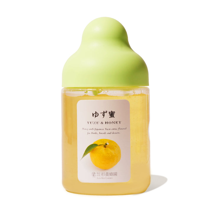 A bottle of Sugi Bee Garden Fruit Juice Infused Honey: Yuzu with a green lid.