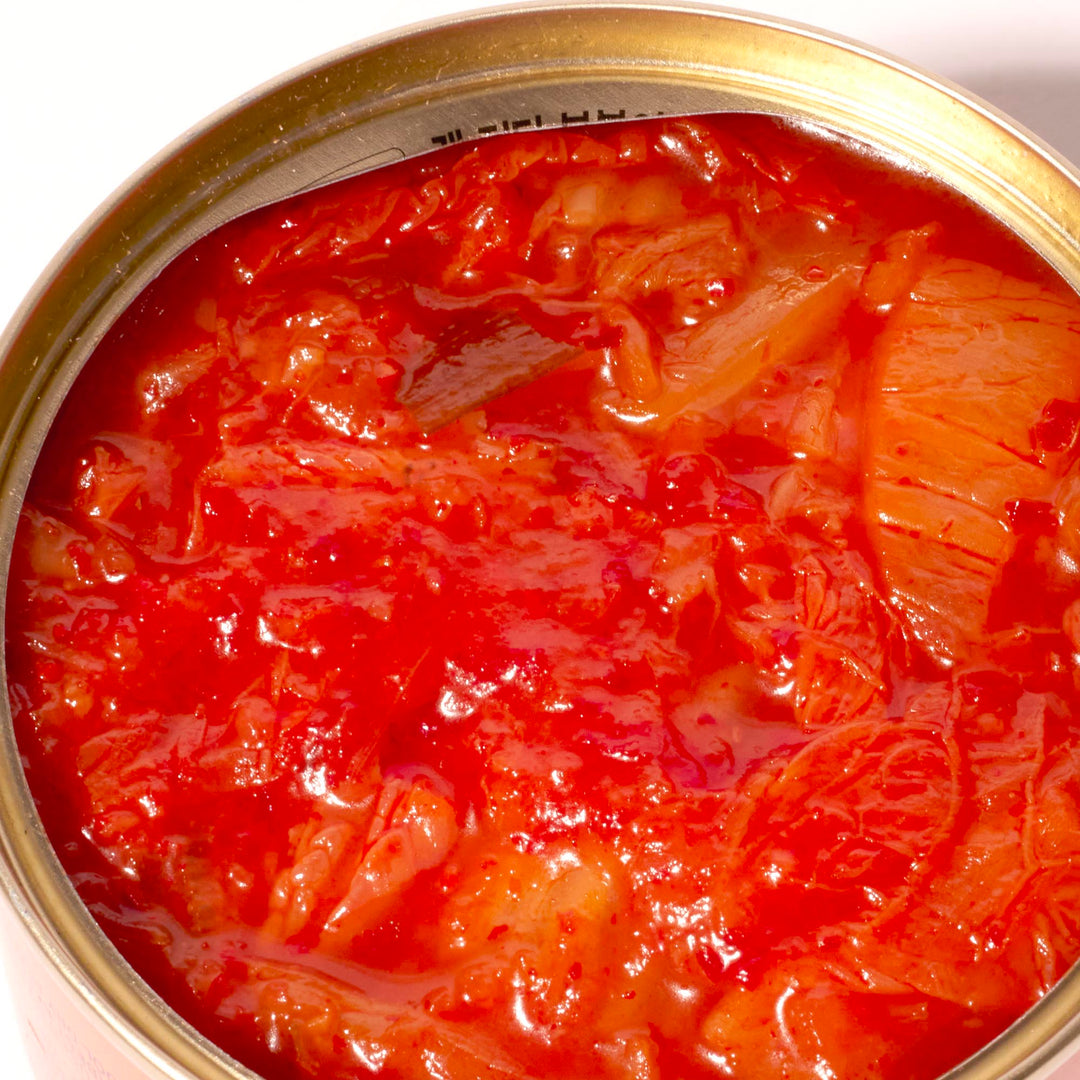 A can of Wang Tinned Stir-Fried Kimchi on a white surface.