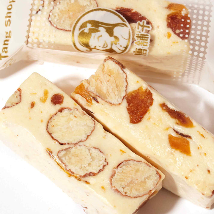 Three pieces of W.Z. Taiwan Nougat Candy: Mango sitting on a white plate.