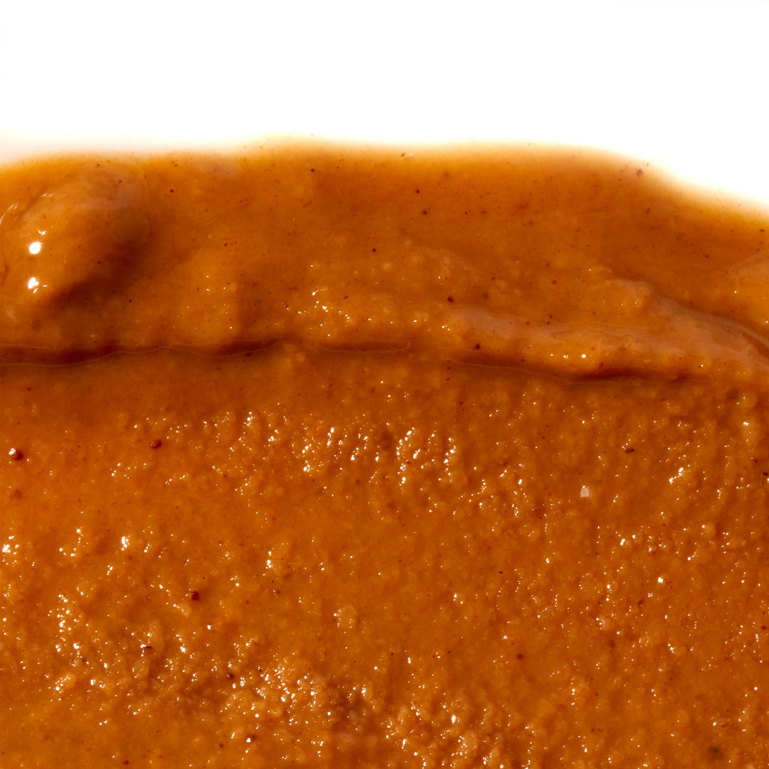 A brown sauce made with Onetang Organic Sesame Paste on a white plate.