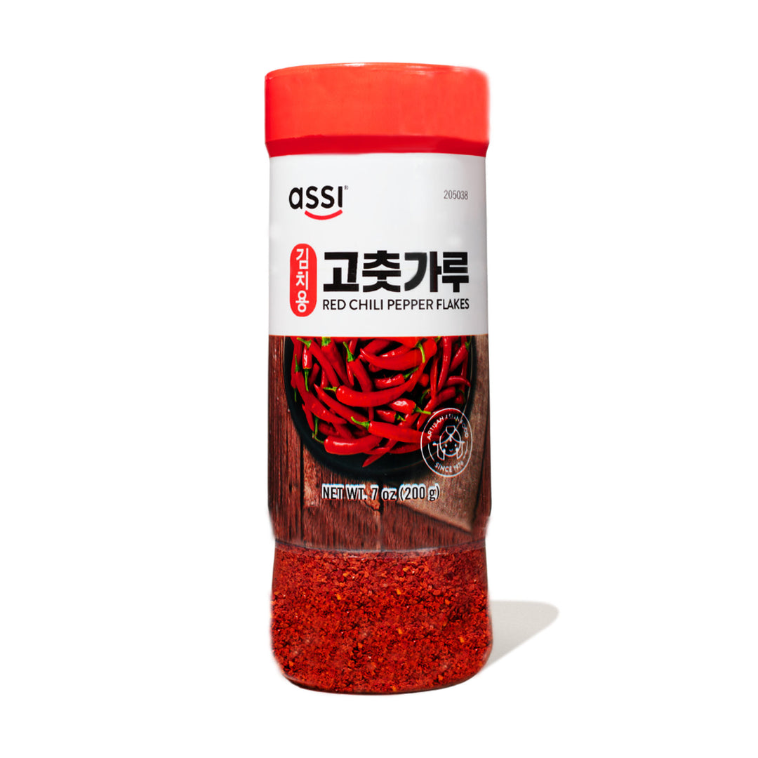 An Assi Gochugaru Red Pepper Flakes bottle on a white background.