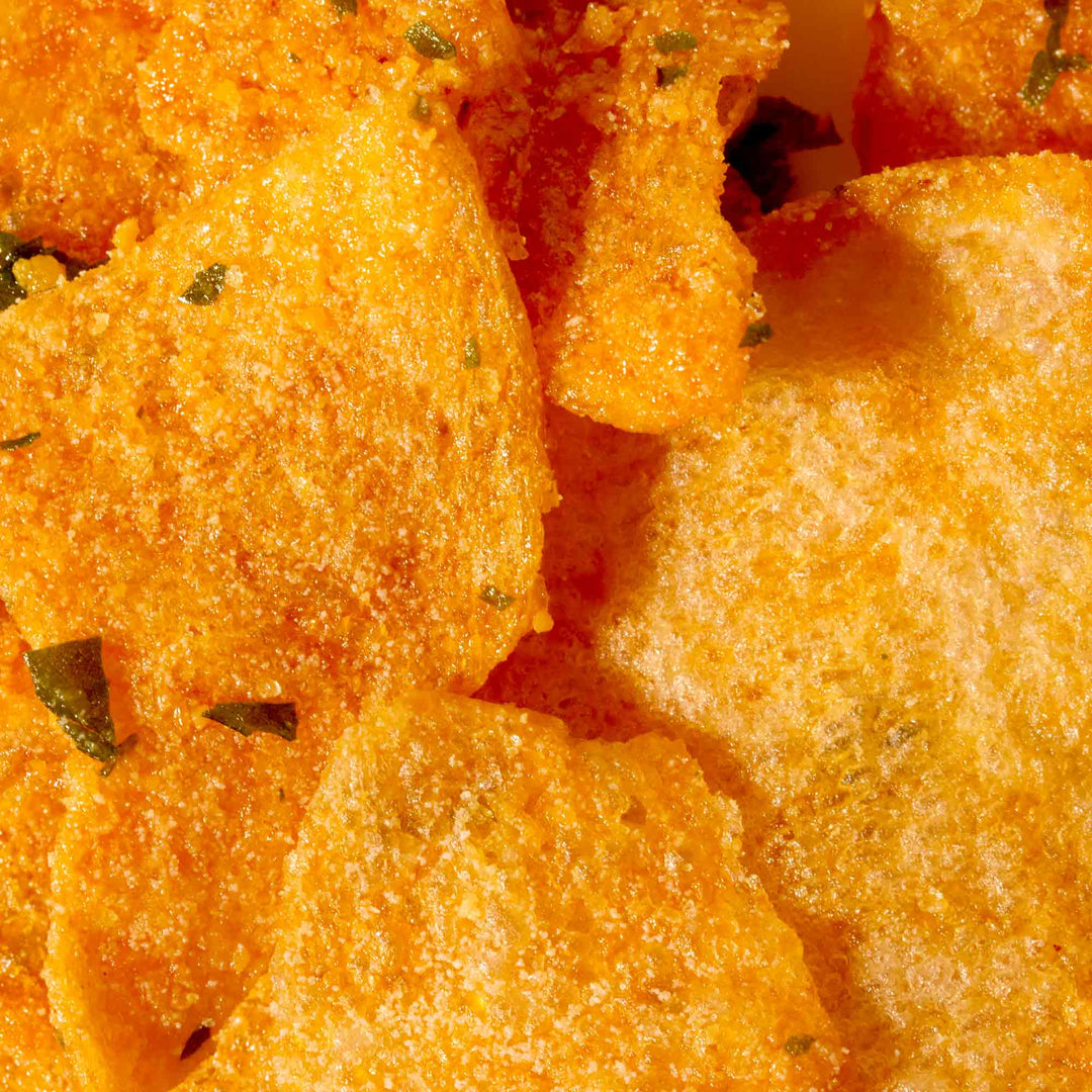 A close up of some Irvins Salted Egg Potato Chips with herbs on them.