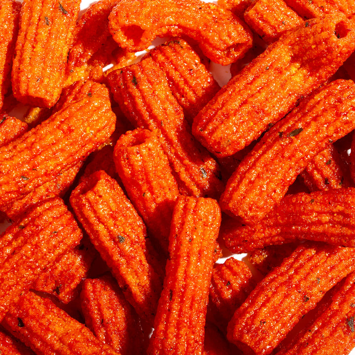 A pile of Cosmos Tteokbokki Rice Cake Chips on a white surface.