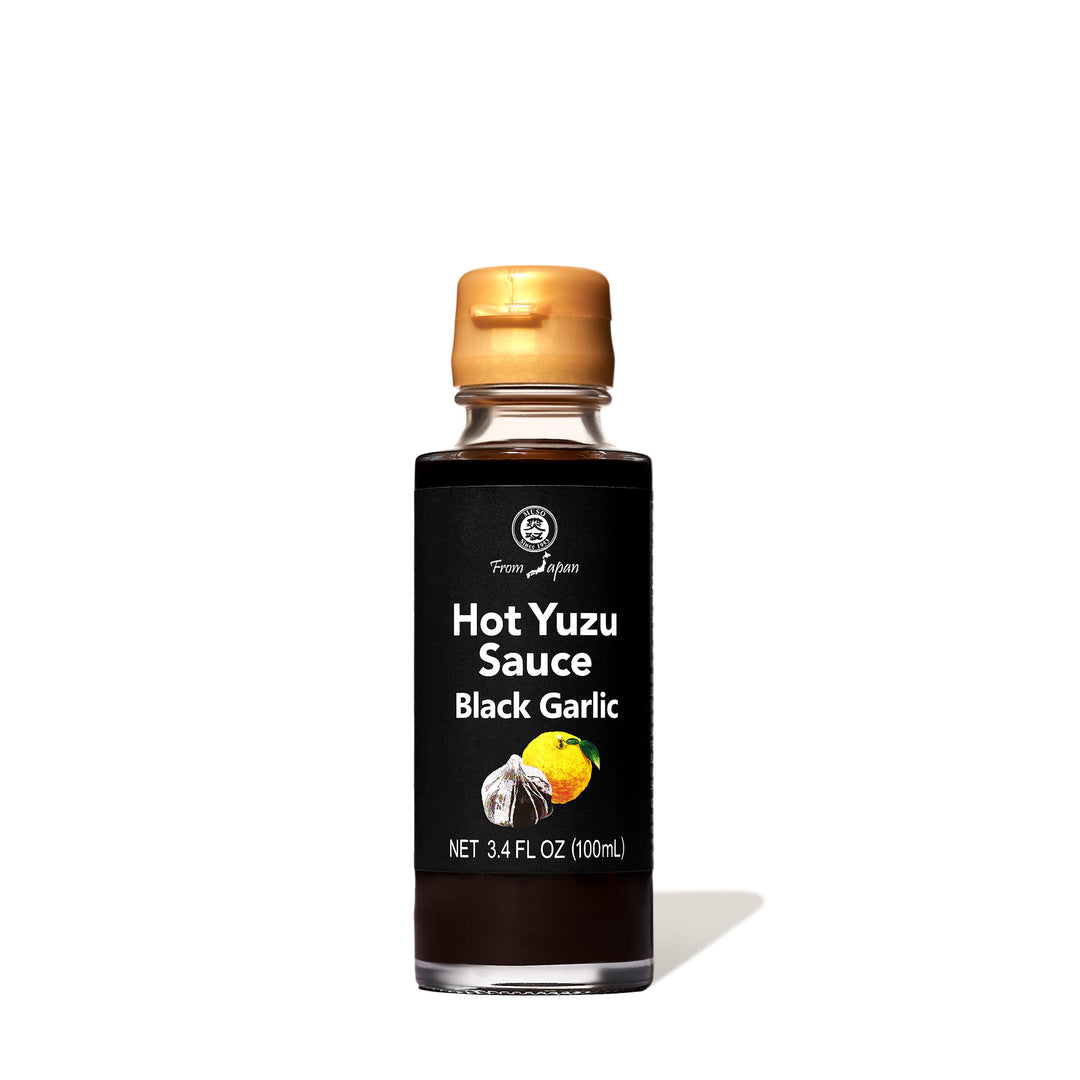 A bottle of Muso Hot Yuzu Sauce: Black Garlic on a white background.