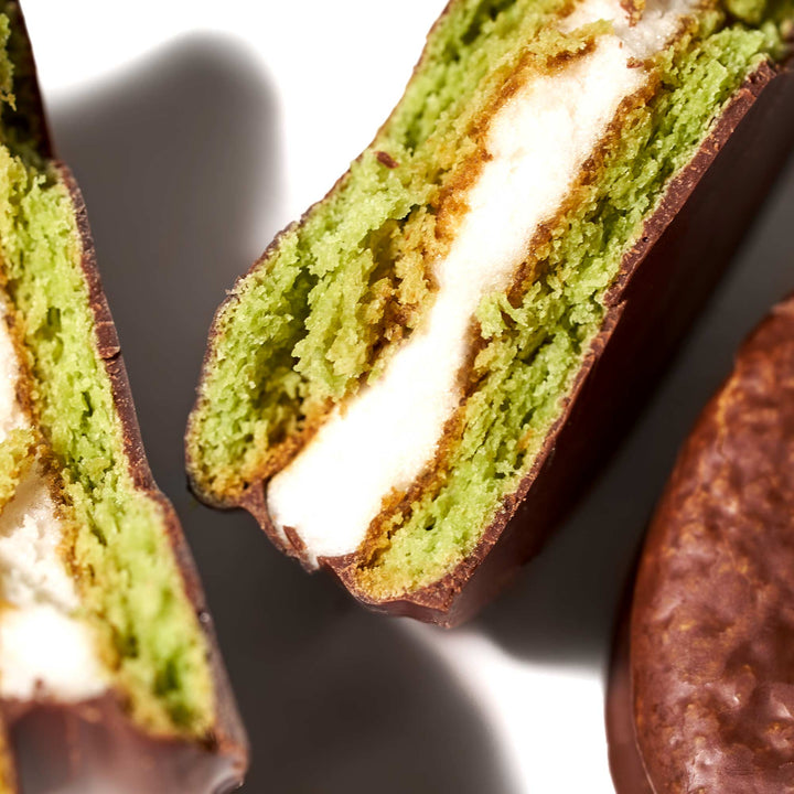 A Lotte Choco Pie: Green Tea (12 pieces) with a green filling is cut in half.
