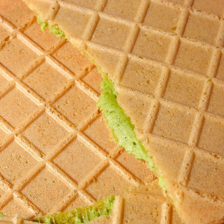 A close up of a Marutou Gaufrette Cream Sandwiches: Matcha (10 pieces) with green icing.
