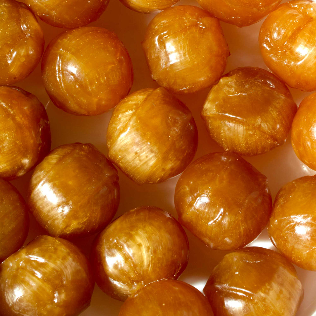 A close up of a bowl of Hongyuan Huamei Sour Plum Candy caramels.