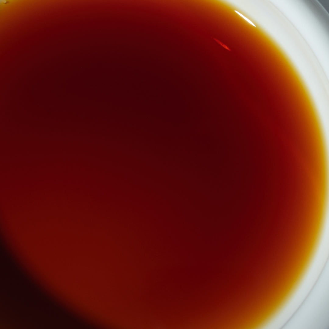 A red liquid of Shibanuma Artisanal Soy Sauce in a cup.