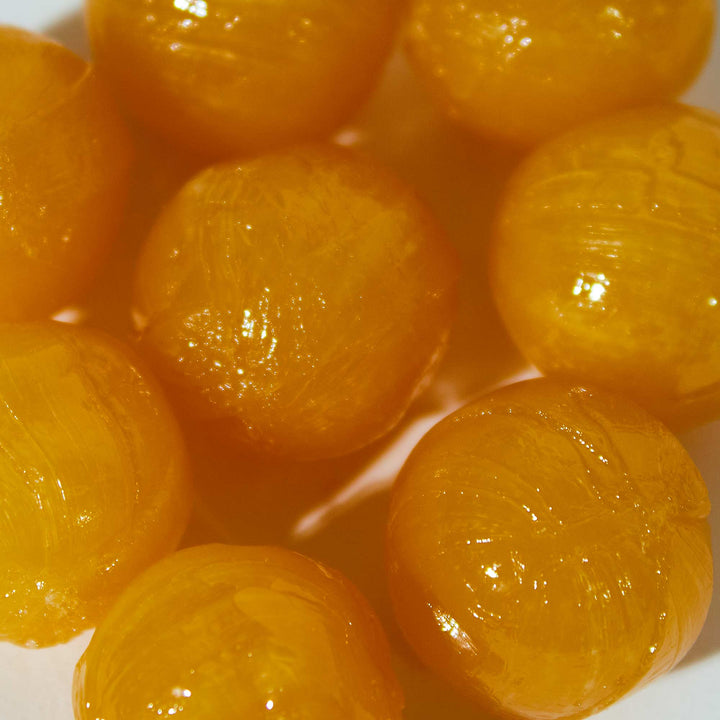 A group of Sapporo Gourmet Foods Hokkaido Melon Candy balls on a white surface.