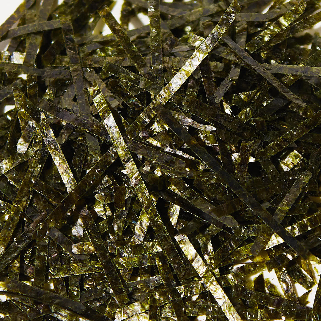 A pile of Shirako Tokyo Kizami Nori Shredded Seaweed on a white surface.