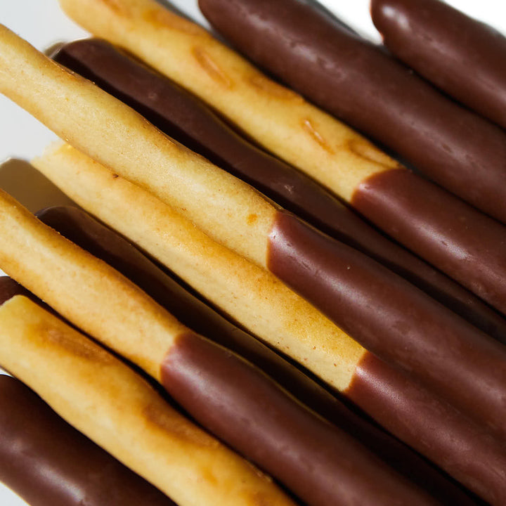 Glico Pocky: Tasty Chocolate with Cultured Butter covered pretzel sticks on a white plate.