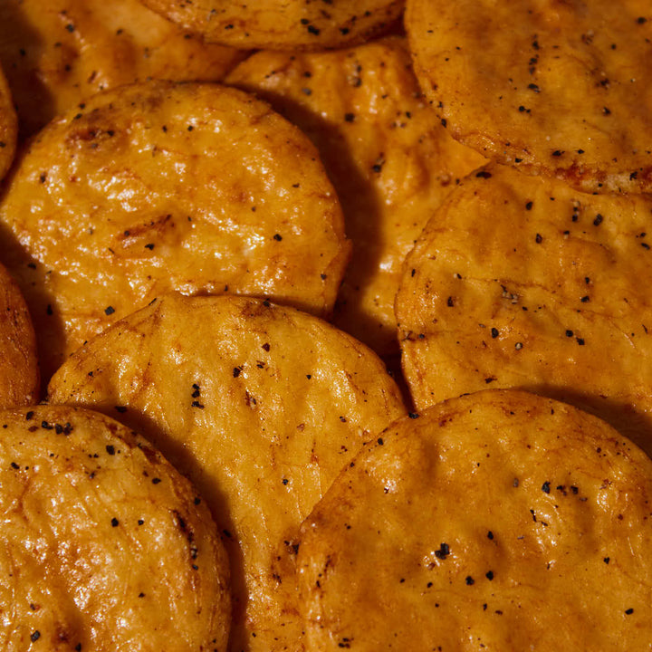A close up of a plate of Kingodo Rice Crackers: Black Pepper.