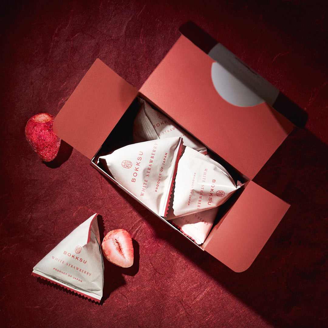 A Bokksu White Strawberry 6-Piece Box - Free Gift with a strawberry in it and a piece of paper.