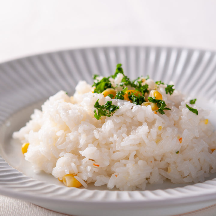 A white Kuze Fuku plate with Kuze Fuku rice and parsley on it.