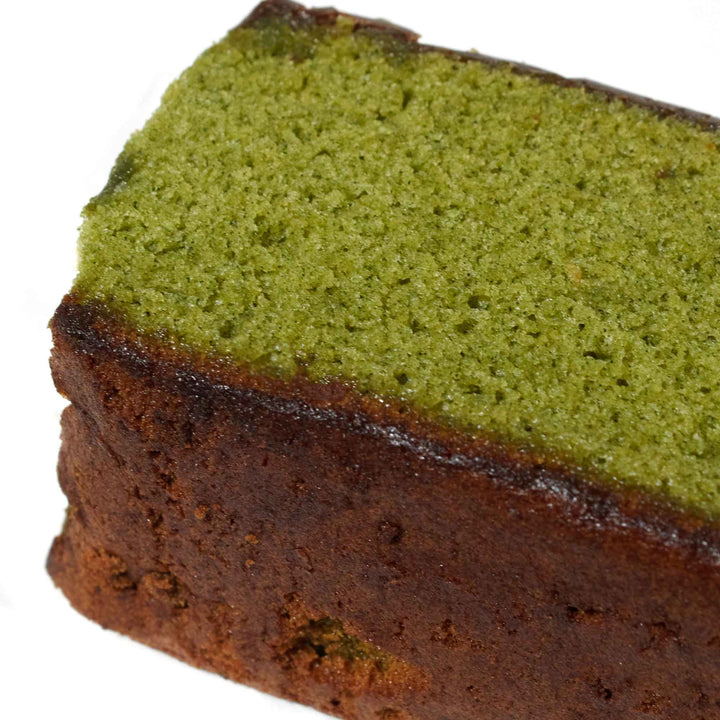 A slice of Karaku Castella: Green Tea cake on a white surface.