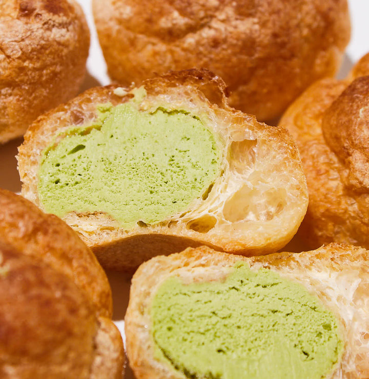 A group of Patisserie Petit Cream Puff: Uji Matcha Green Tea (12 pieces) pastries with green ice cream inside made by Orange.