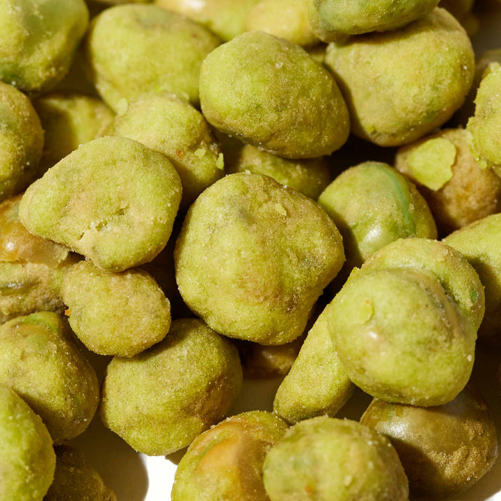 A pile of Hapi Hot Wasabi Peas on a white surface.
