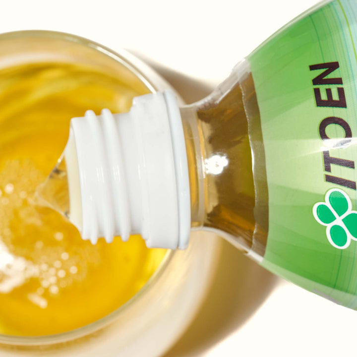 A bottle of Itoen Oi Ocha Green Tea: Cold Brew is being poured into a glass.