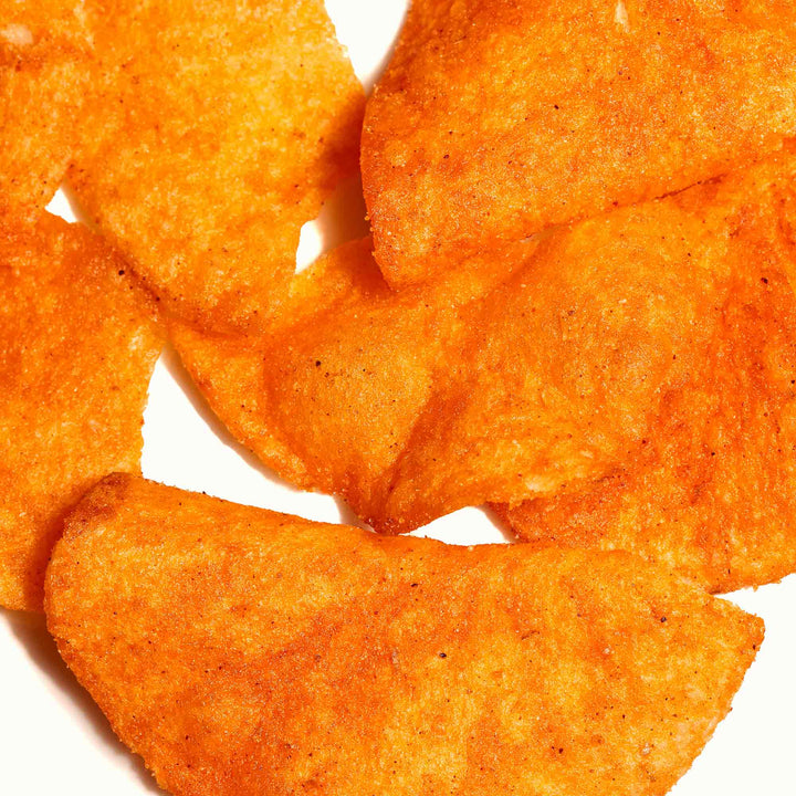 A pile of Koikeya Karamucho Spicy Potato Chips on a white surface.