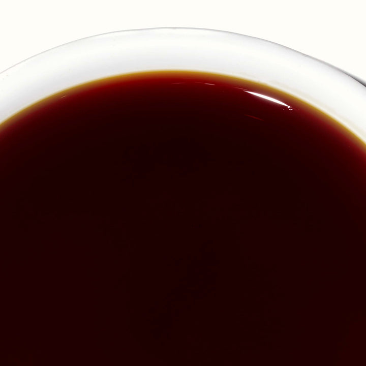A cup of Kikkoman Gluten-Free Soy Sauce on a white background.