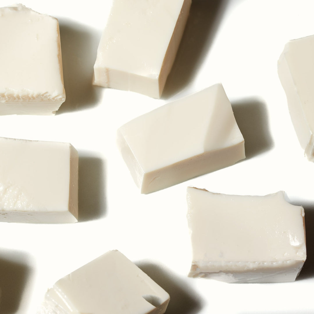 A group of Mori-Nu Silken Tofu: Extra Firm cubes on a white surface.