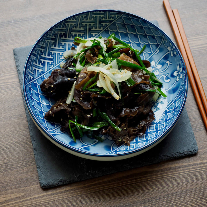 A blue and white plate of Lokfook Dried Wood Ear Mushrooms with chopsticks.