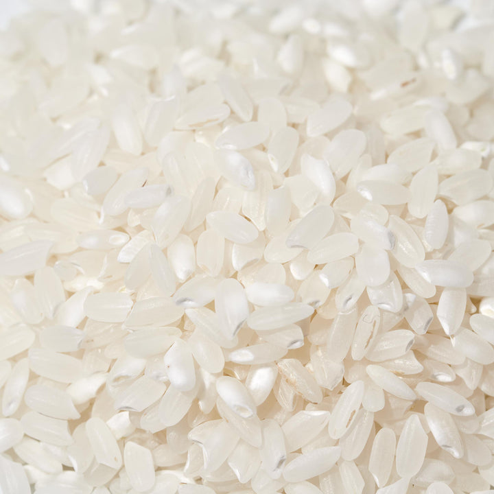 A pile of Nishiki Premium Rice: Medium Grain 5 lb on a white background.