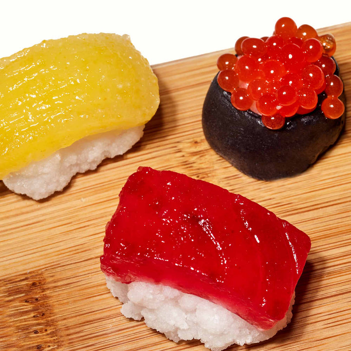 Three different kinds of Kracie Popin Cookin DIY Candy: Sushi on a wooden cutting board.