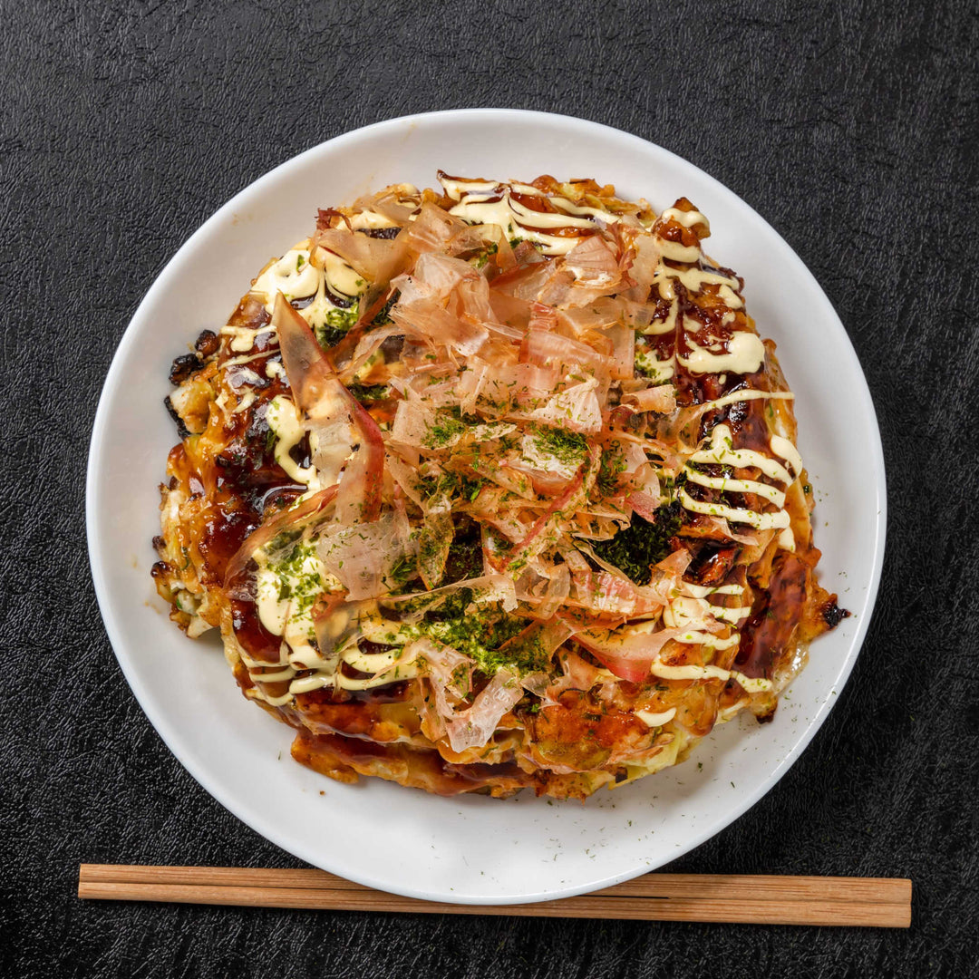 Otafuku Okonomiyaki Japanese Pancake on a plate with chopsticks.