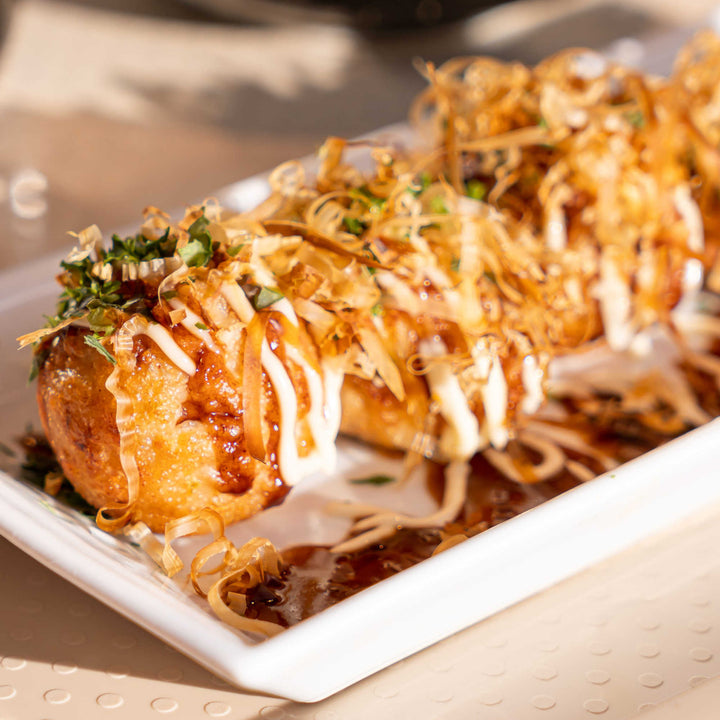 A white plate with J-Basket Takoyaki Japanese Octopus Balls (18 pieces) on it.