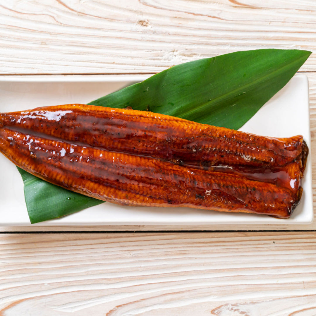Two Unagi Kabayaki Grilled Eel on a plate with a leaf. (Brand Name: Ichiban)