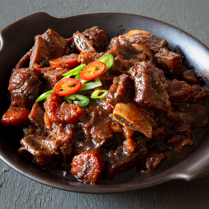 A bowl of stew with Wagyuman A5 Wagyu Beef Short Rib: BBQ Cut (0.5 lb) and vegetables in it.